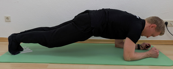 Plank: Auf dem Boden, auf den Unteramen und den Füßen abstützen.