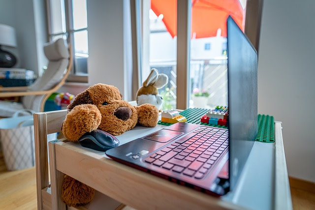 Rückenschmerzen im Homeoffice zeigt Plüschtiere, die an einem Kindertisch sitzen. Auf dem Tisch ist ein Tablet und Spielzeug.