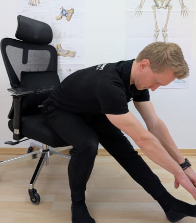 Sitzend den Ischias und unteren Rücken Dehnen, um dem Hohlkreuz die Spannung zu nehmen. Ein Bein ausstrecken und mit dem Oberkörper vorbeugen.