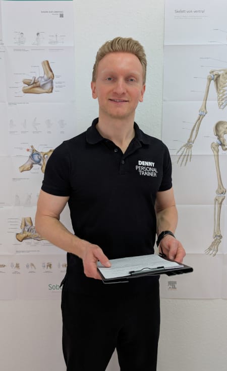 Denny Burkhardt steht aufrecht mit einem Klemmbrett in beiden Händen.