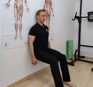 Denn lehnt mit dem Rücken gegen eine Wand in der Sitzposition.