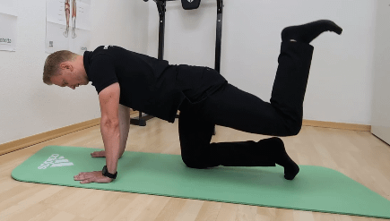 Wie lange dauert es ein Hohlkreuz wegzubekommen: Denny ist im Vierfüßlerstand. Ein Bein ist nach hinten-oben gehoben. (Donkey Kick)